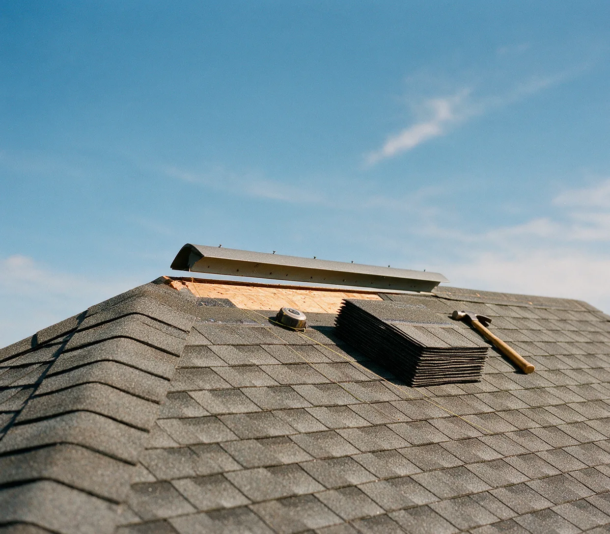 A new ridge vent being fastened along an open roof peak